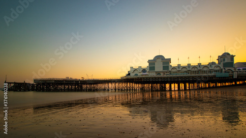 An english pier reflecting on wet sand at sunset, south parade pier, Southsea photo