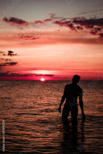 A man on the sea against the sunset. Red sunset