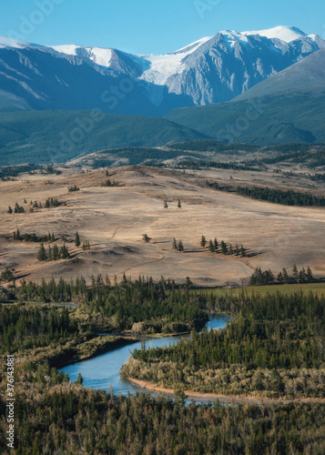 Autumn veiw with a bend of a rive and white snowy mountains in the background. Chuya River, Altai mountains, Siberia, Russia