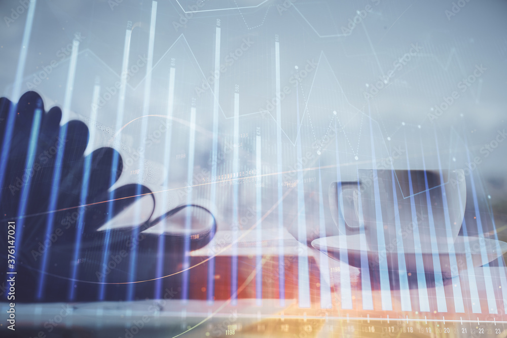 Double exposure of financial chart drawing and desktop with coffee and items on table background. Concept of forex market trading Double exposure of financial chart drawing and desktop with coffee and items on table background. Concept of forex market trading