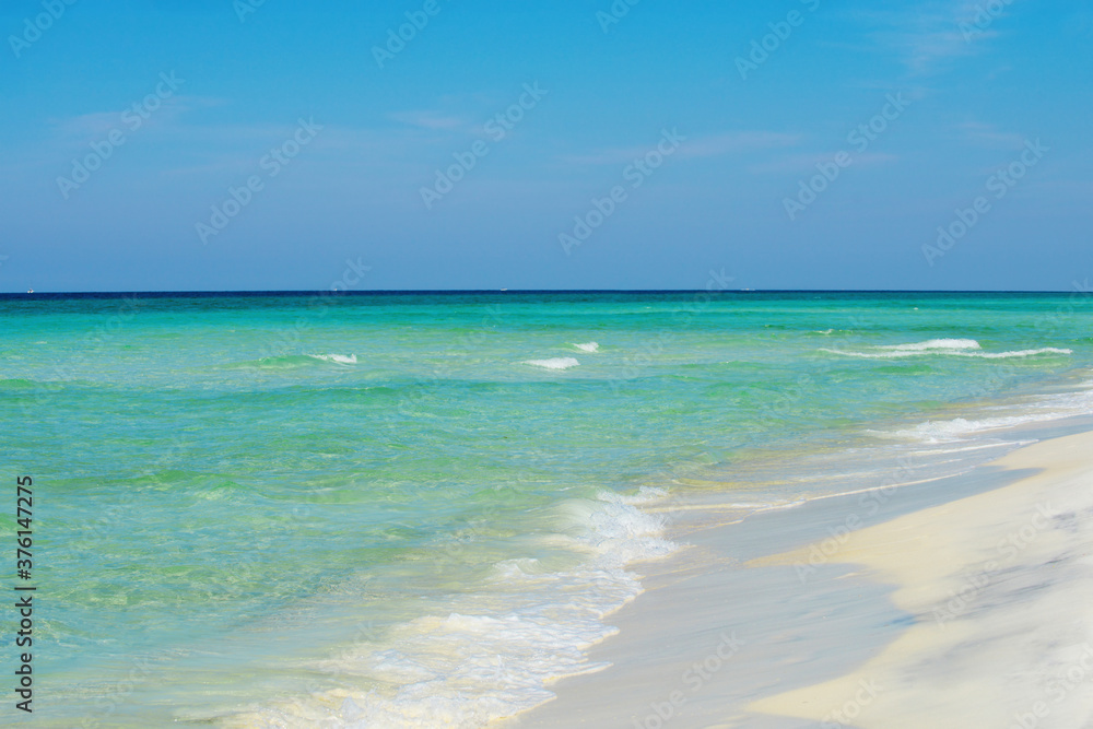 Clouds with blue sky over calm sea beach in tropical Maldives island. Beautiful beach with palm trees and moody sky.