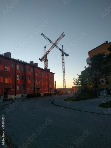 Stockholm, Sweden - October 18 2018: the view of two cranes in a construction site behind a red apartment building on October 18 2018 in Stockholm Sweden.