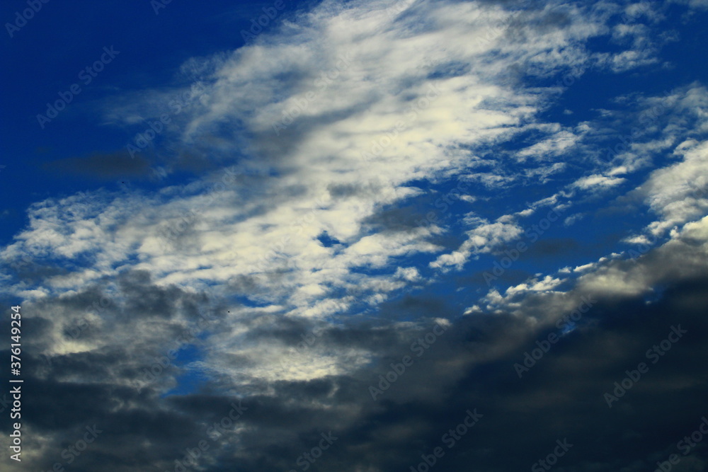 Białe i ciemne chmury na tle błękitnego nieba