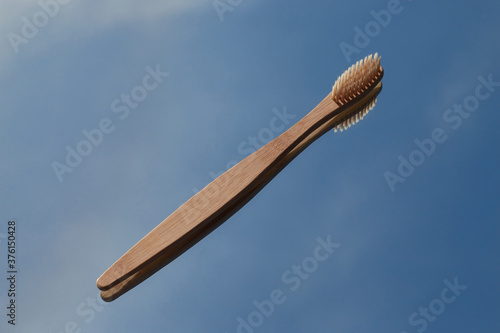 Dark bamboo toothbrushes are reflected in the mirror against the blue sky. Oral cavity care and protection
