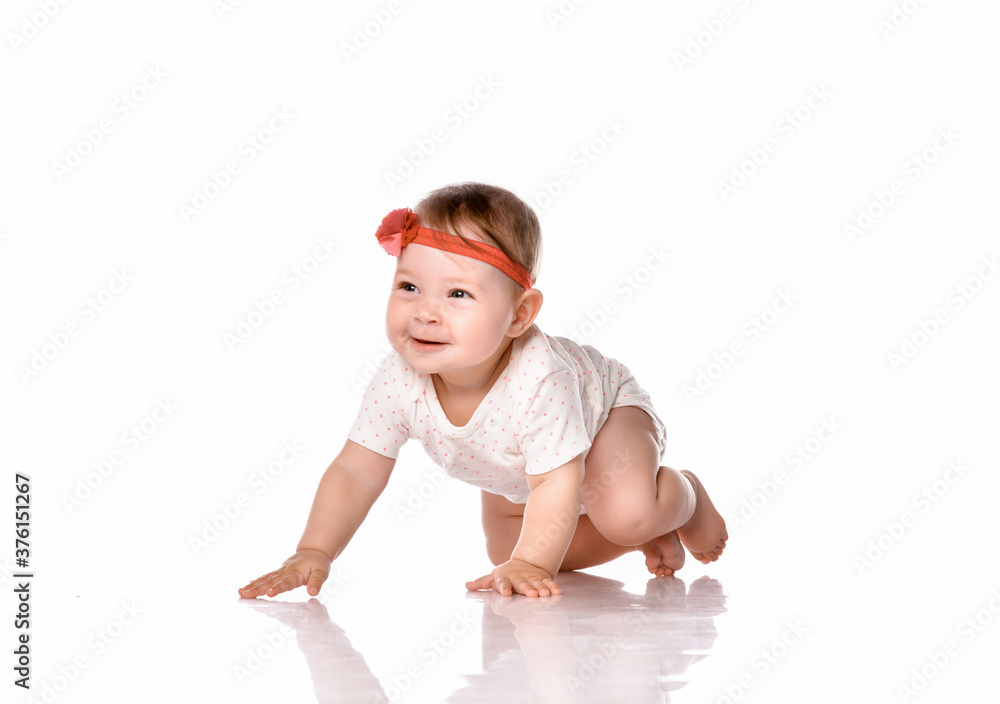 Smiling baby girl crawls on all fours on a white background. Smiling baby girl crawls on all fours on a white background.