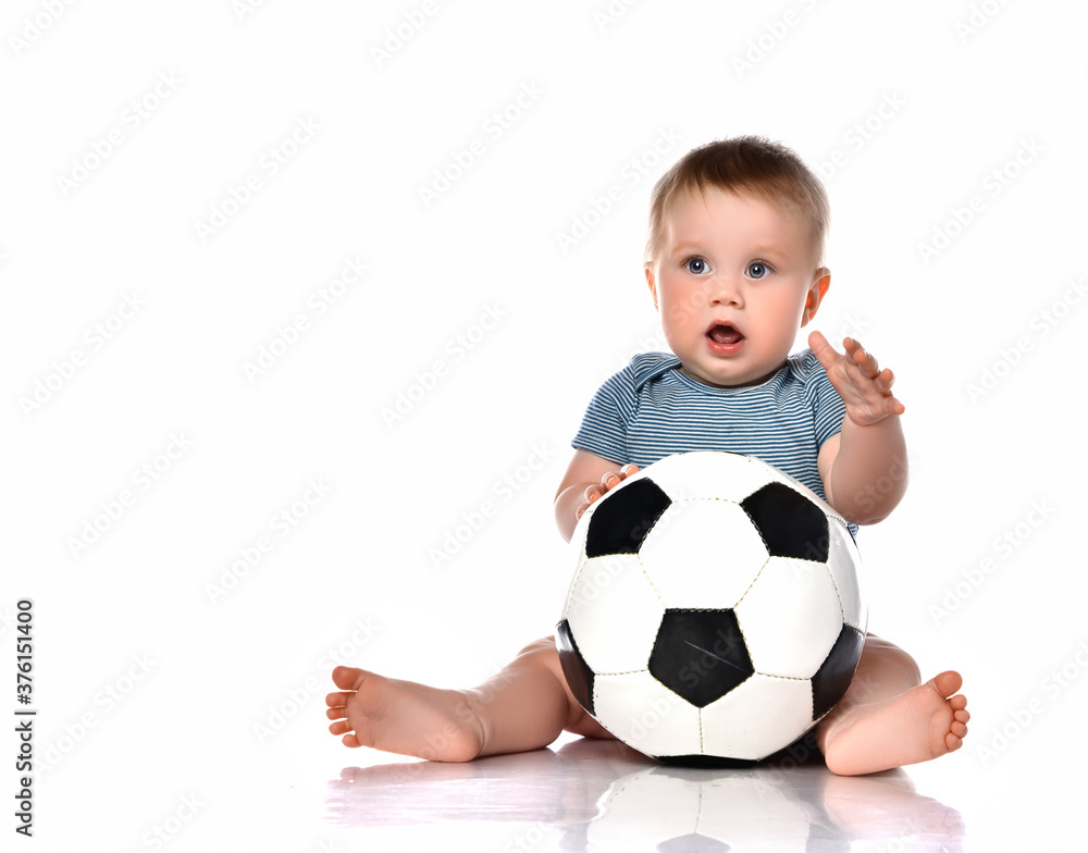 Little kid boy playing a new soccer ball on a white background. Little kid boy playing a new soccer ball on a white background.