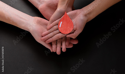 Fotografie Hands holding a drop of blood, blood donation, blood transfusion, world blood do