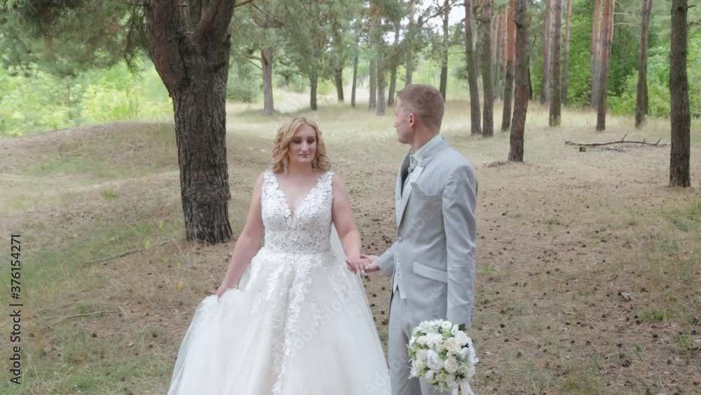 Very beautiful bride and groom are walking in the forest in summer. Very beautiful bride and groom are walking in the forest in summer.