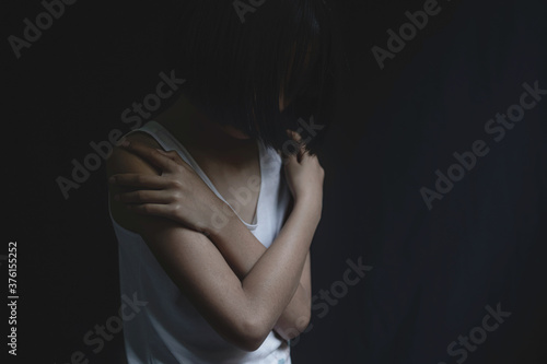 Portrait of sad little girl standing on black background, fear child, . human trafficking concept.