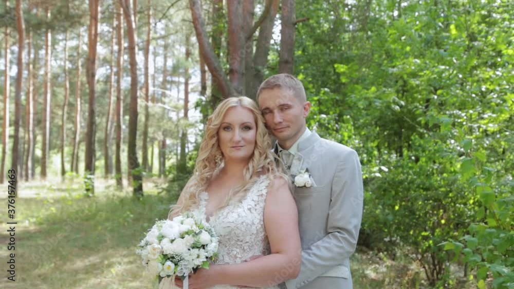 Gorgeous bride and groom hugging and kissing in summer forest. Gorgeous bride and groom hugging and kissing in summer forest.