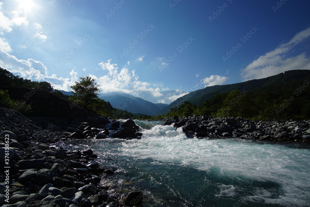 landscape with mountains, forest and a river in front. beautiful scenery of Japanese alps, Hakuba, Japan