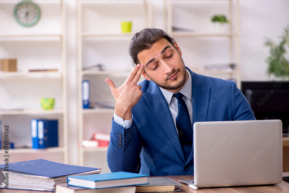 Young male employee unhappy with excessive work Young male employee unhappy with excessive work