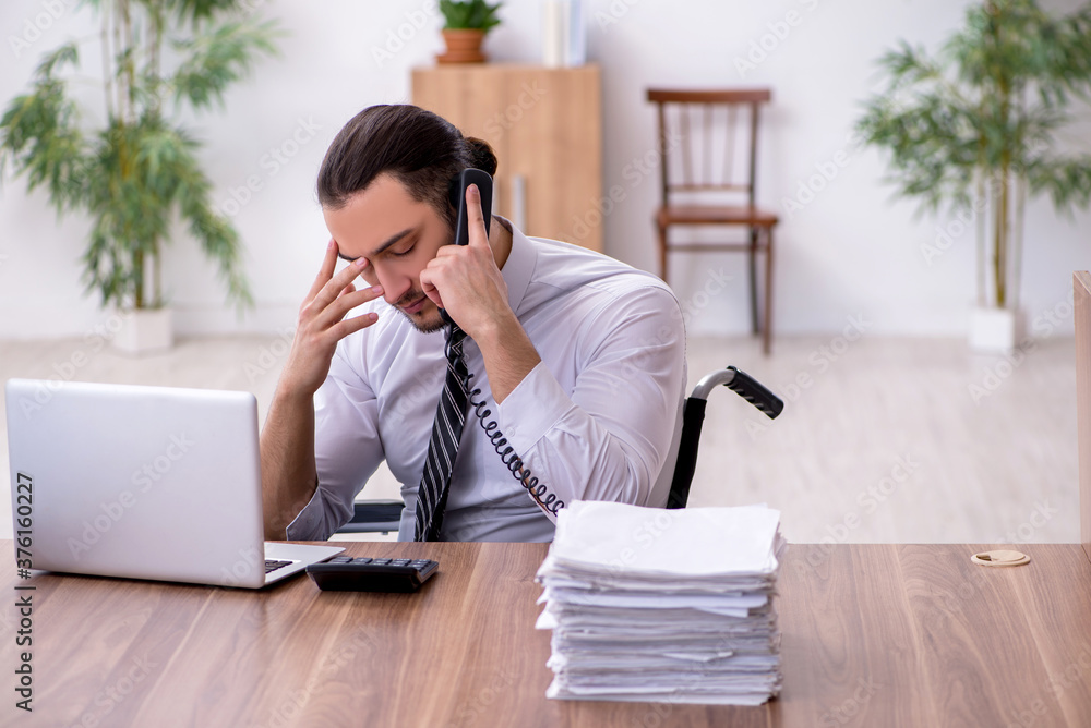 Young disabled employee suffering at workplace Young disabled employee suffering at workplace