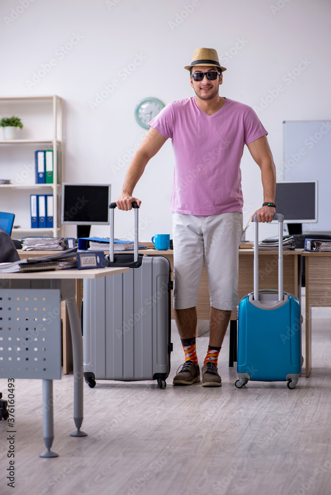 Young male employee preparing for the trip Young male employee preparing for the trip