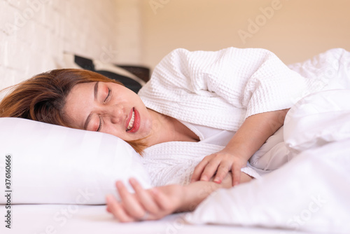 Asian woman sleeping on the bed and grinding teeth,Female tiredness and stress photo