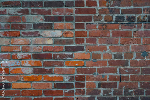 old rustic brick wall background with multi colored bricks and different sizes for old historic wall texture pattern