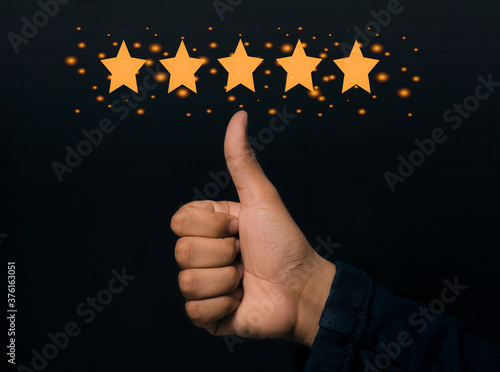 Businessman shows a five-star thumbs up symbol to increase their score Excellent company photo