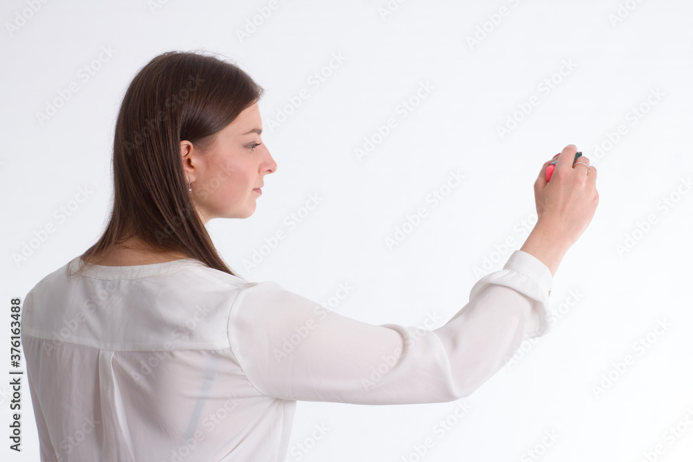 A young business woman a background isolated in white, in white shirts, standing back, writing on copy space A young business woman a background isolated in white, in white shirts, standing back, writing on copy space