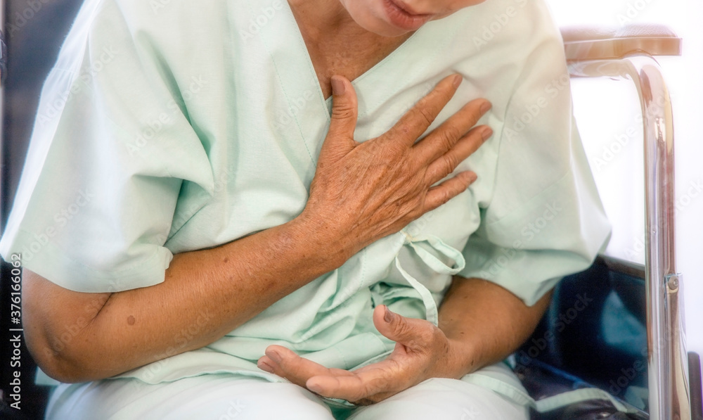 Obraz premium Health problem concept; An elder woman touches her chest, she fell tired and waits to meet the doctor at the hospital.