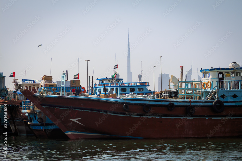 Shipping boat docked in Dubai Creek Harbor in Dubai with skyline in the background