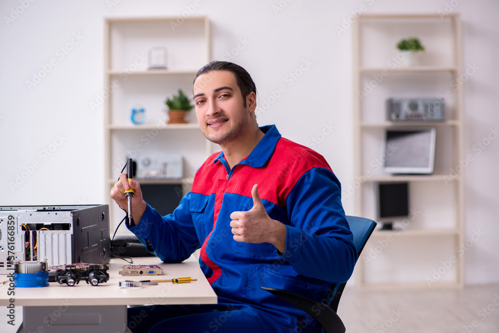 Fototapeta premium Young male repairman repairing computer