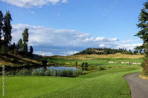 Slika na platnu A beautiful view of a par 4 dog leg left from a tee box over a lake