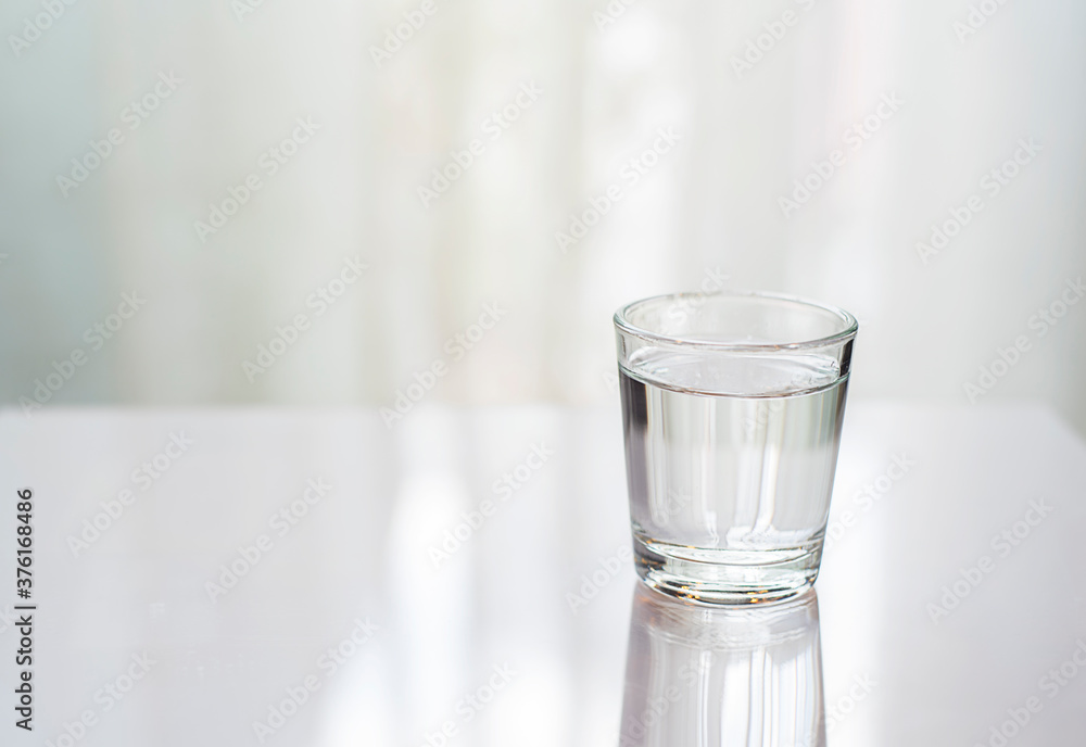 A glass cup of water on the table(desk). A glass cup of water on the table(desk).