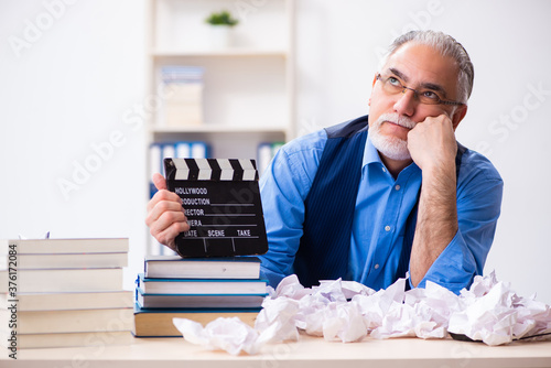 Foto Old male author writing screenplay