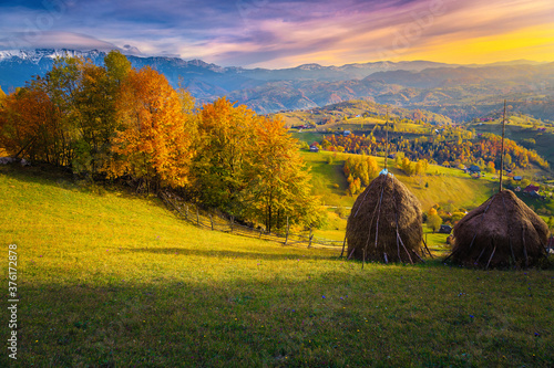 Admirable autumn countryside scenery with haystacks on the hills, Romania