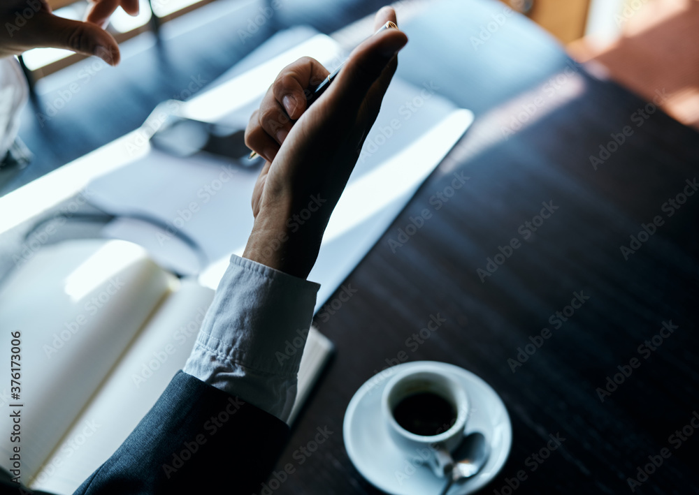 Business man in a cafe documents a cup of coffee on the table official work