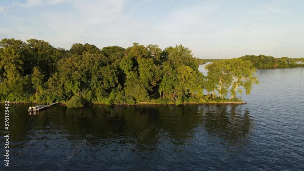 houses in a island in the middle of a lake in minnesota, during summer time houses in a island in the middle of a lake in minnesota, during summer time