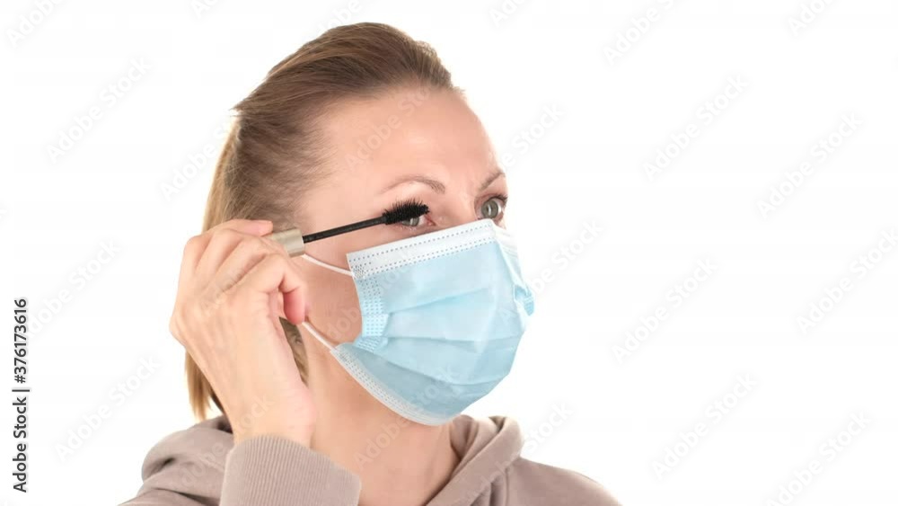 woman in protective mask paint eyelashes with mascara. corona virus prevention and makeup woman in protective mask paint eyelashes with mascara. corona virus prevention and makeup