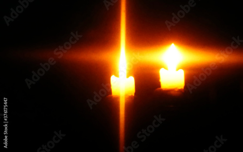 burning candles with beams in a cross