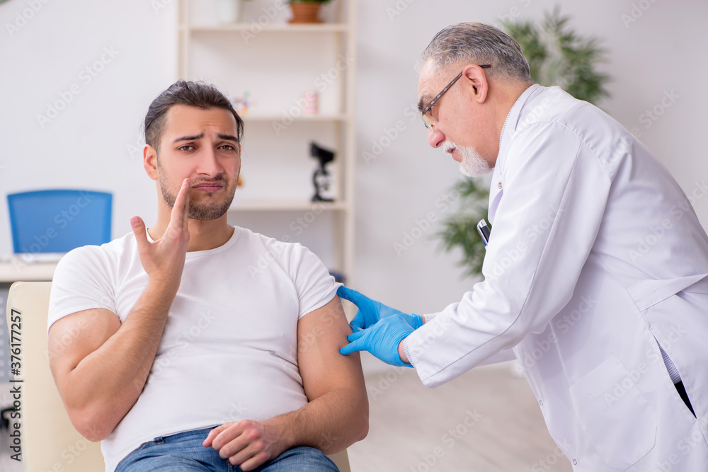 Fototapeta premium Young man visiting experienced doctor dermatologist