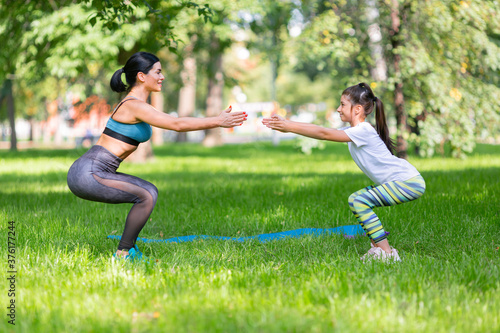 Mom and daughter working out together in city park