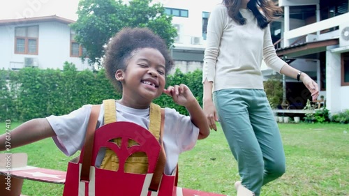 Happy child playing with a toy paper plane in nature during summer.Girl is walking with a plane dreams of being a pilot. Slow motion.she runnung with family father or mother.