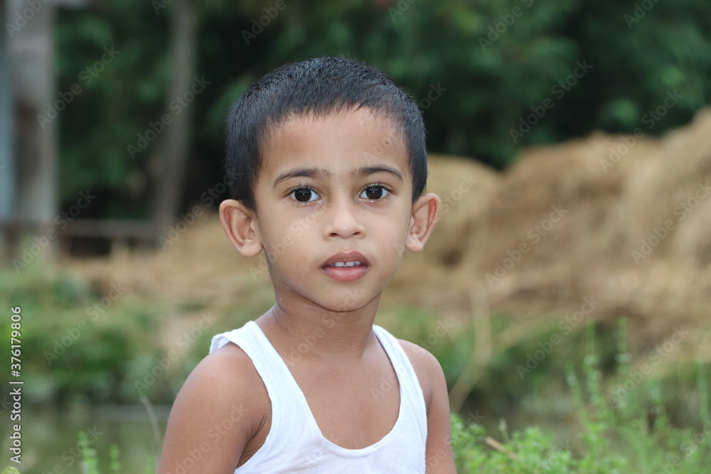 Portrait of 3 years old asian boy child standing beside a pond and looking at the camera Portrait of 3 years old asian boy child standing beside a pond and looking at the camera