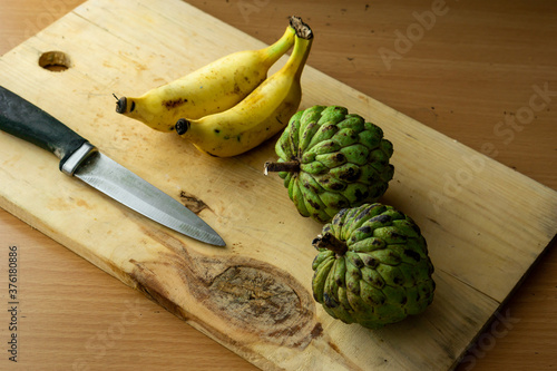 Banana and custard fruit on a yellow chop board