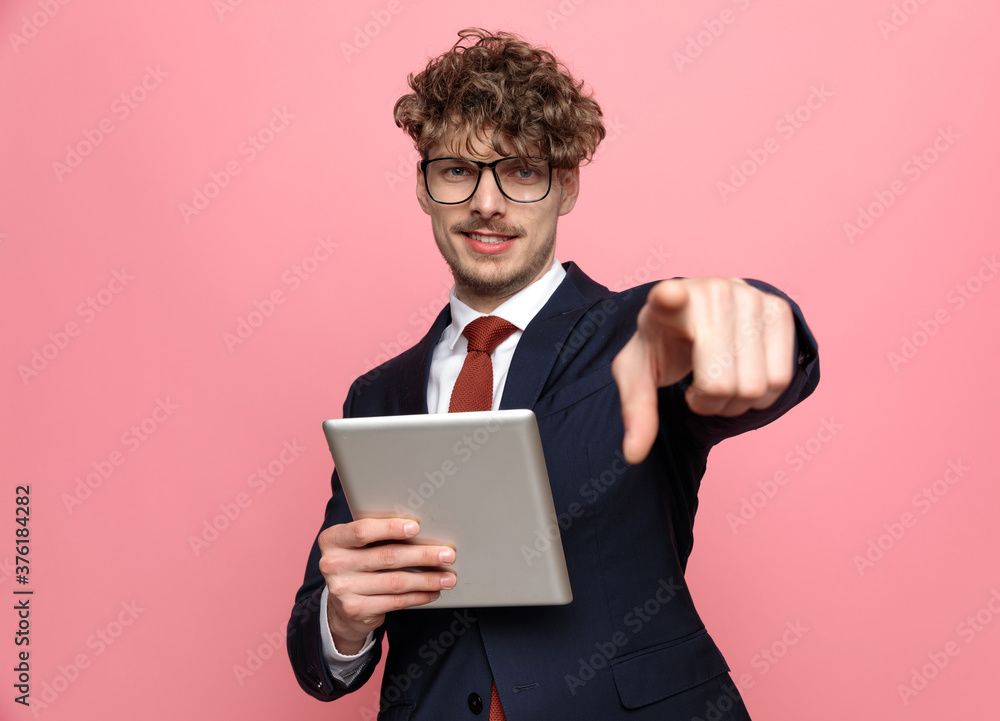 elegant young businessman wearing tab and pointing finger elegant young businessman wearing tab and pointing finger