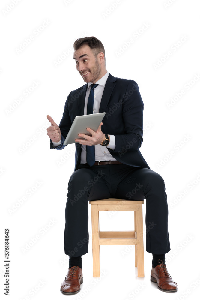 Excited businessman presenting tablet and gesturing okay Excited businessman presenting tablet and gesturing okay