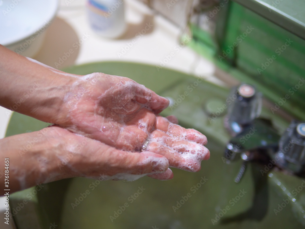 ハンドソープで手を洗う女性の手