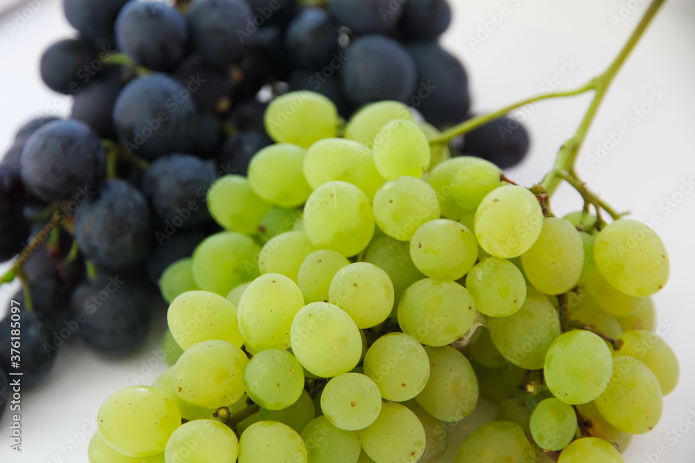 Green grapes . Large bunch of fresh fruit with green leaves and white backgrounds Green grapes . Large bunch of fresh fruit with green leaves and white backgrounds
