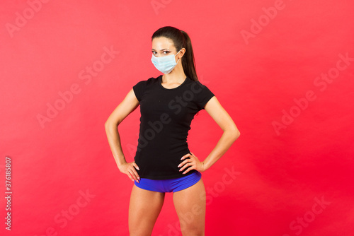 Young fitness woman in sportswear face mask isolated on red background studio. Motivation concept.