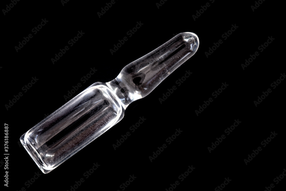 Single Medical glass ampules with transparent solution on black background Single Medical glass ampules with transparent solution on black background