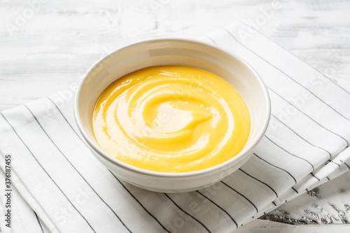 Homemade vanilla custard pudding or lemon curd in a white  bowl. photo