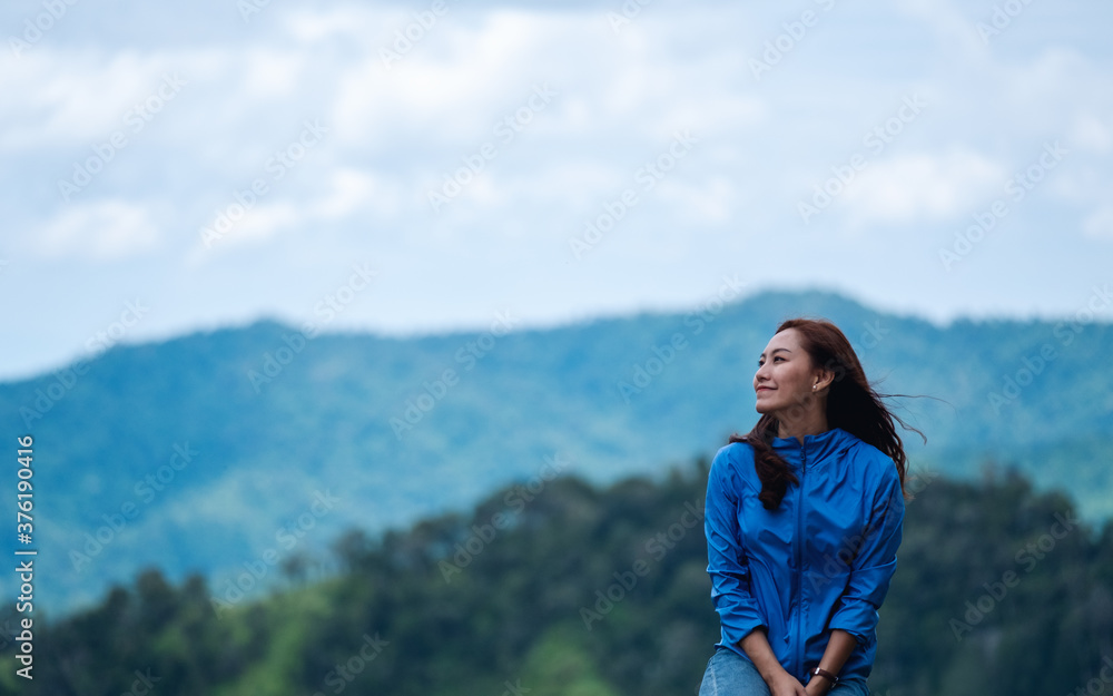 Portrait image of female traveler with a beautiful green mountains view