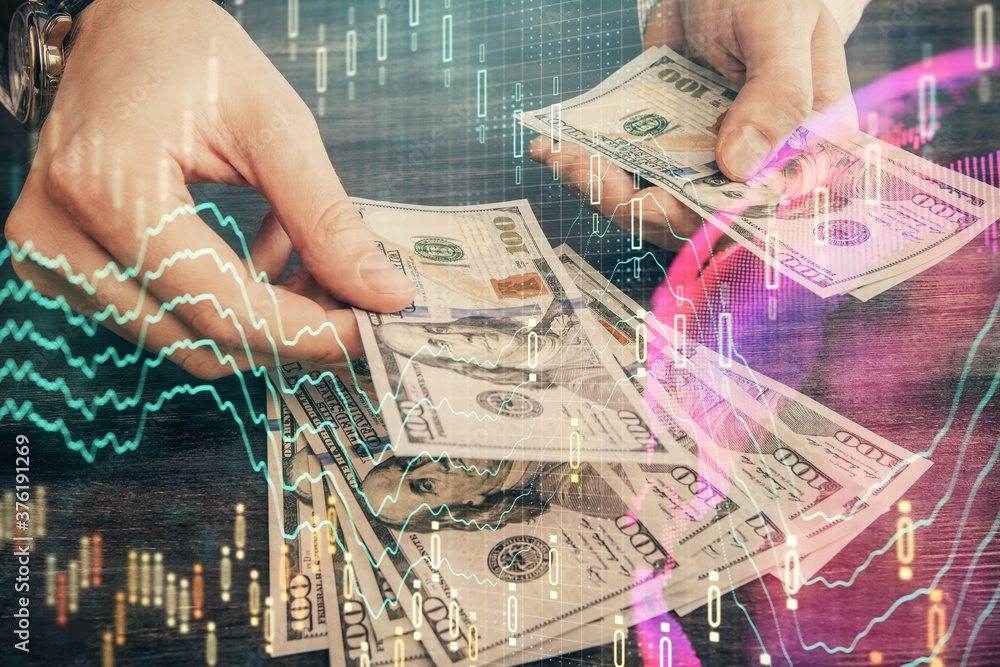 Multi exposure of financial graph drawing hologram and USA dollars bills and man hands. Analysis concept. Multi exposure of financial graph drawing hologram and USA dollars bills and man hands. Analysis concept.