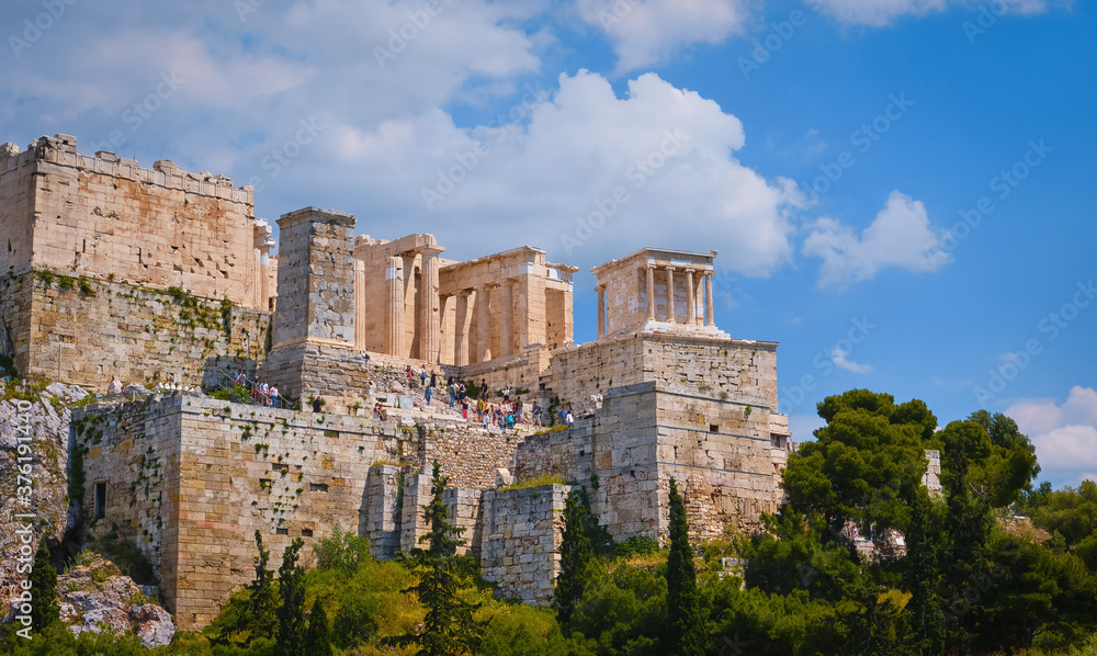 View of Acropolis hill from Areopagus hill in summer day with great clouds in blue sky, Athens, Greece. UNESCO heritage. Propylaea gate, Parthenon.