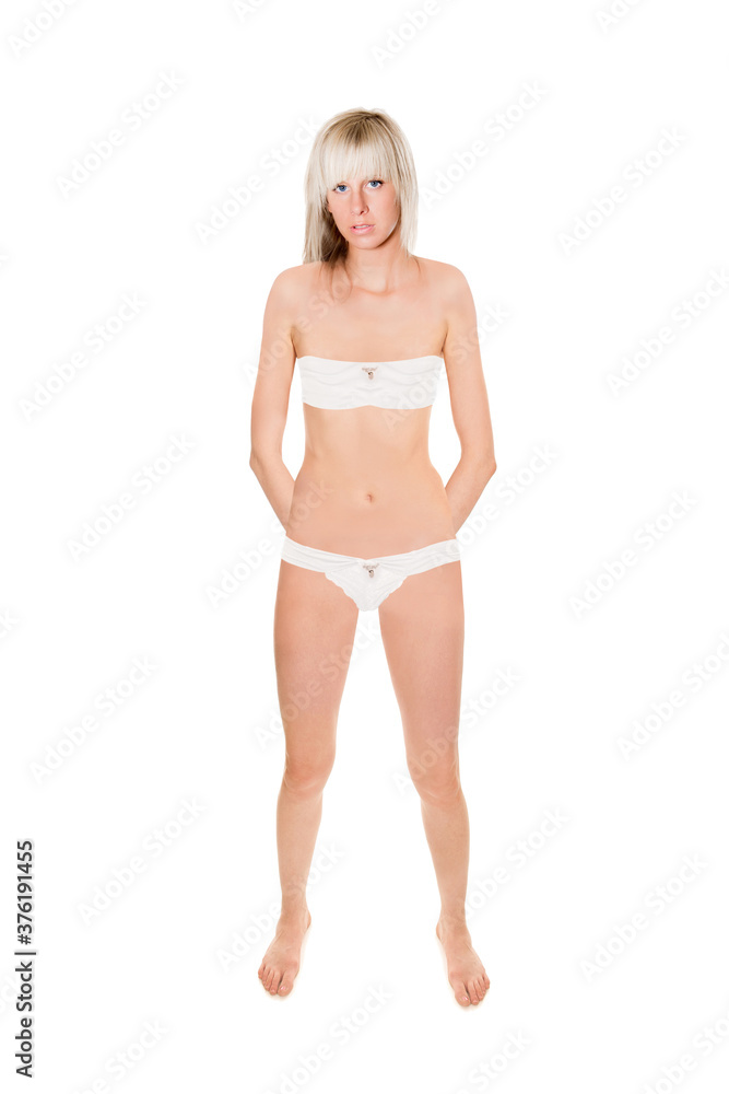 Attractive young blonde woman wearing white bra and panties, full length portrait isolated in front of white studio background Attractive young blonde woman wearing white bra and panties, full length portrait isolated in front of white studio background