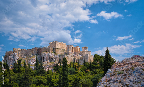 View of Acropolis hill from Areopagus hill on summer day with great clouds in blue sky, Athens, Greece. UNESCO heritage. Propylaea gate, Parthenon.